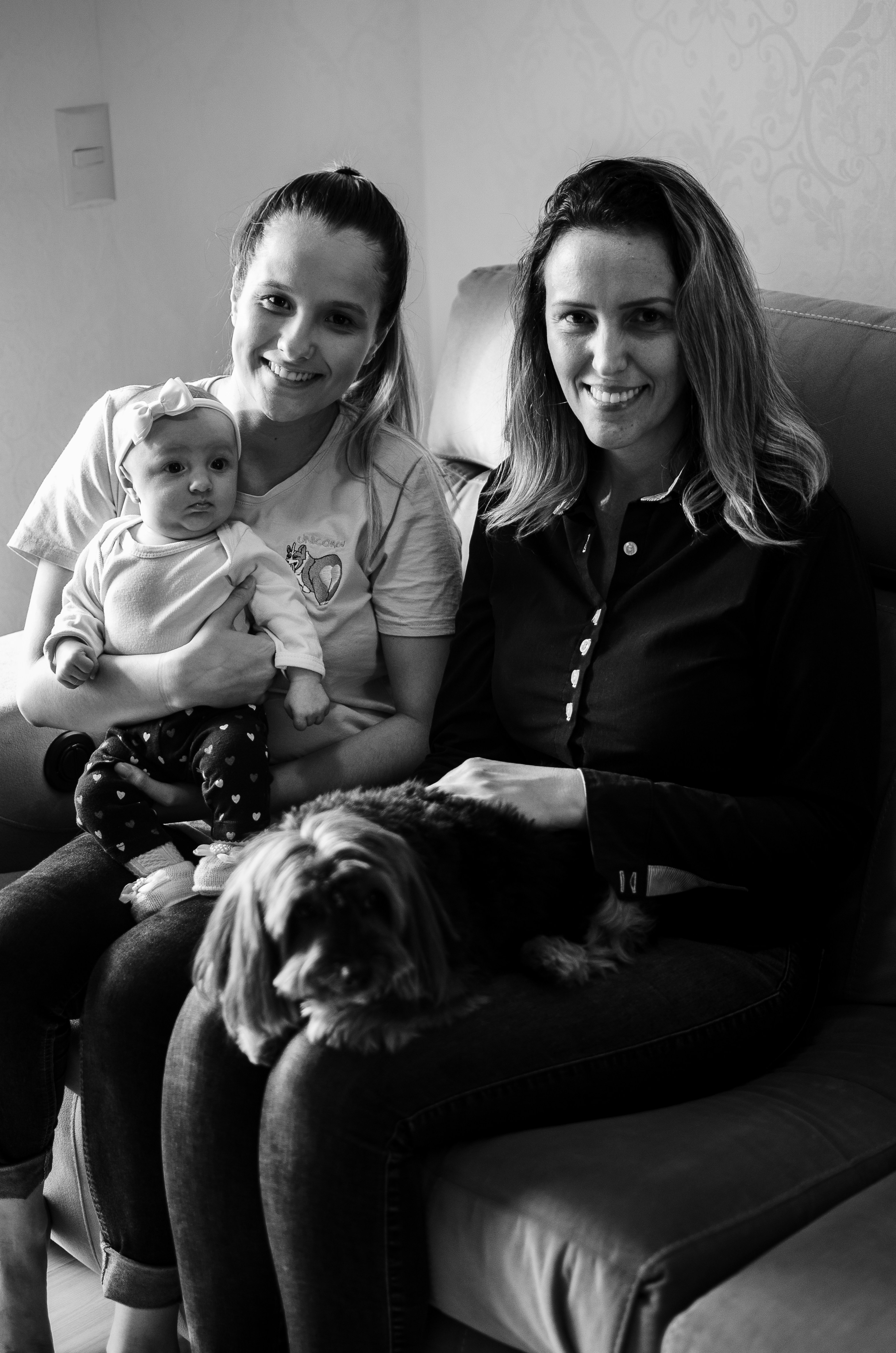 woman in black jacket holding baby in grayscale photography