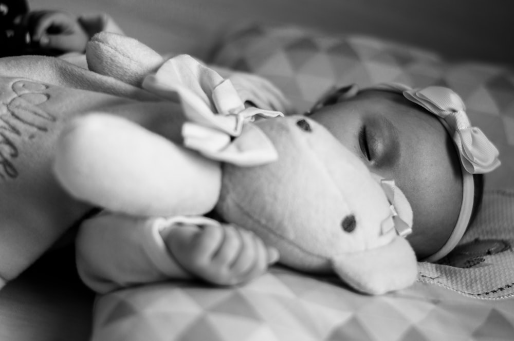 grayscale photo of woman lying on bed