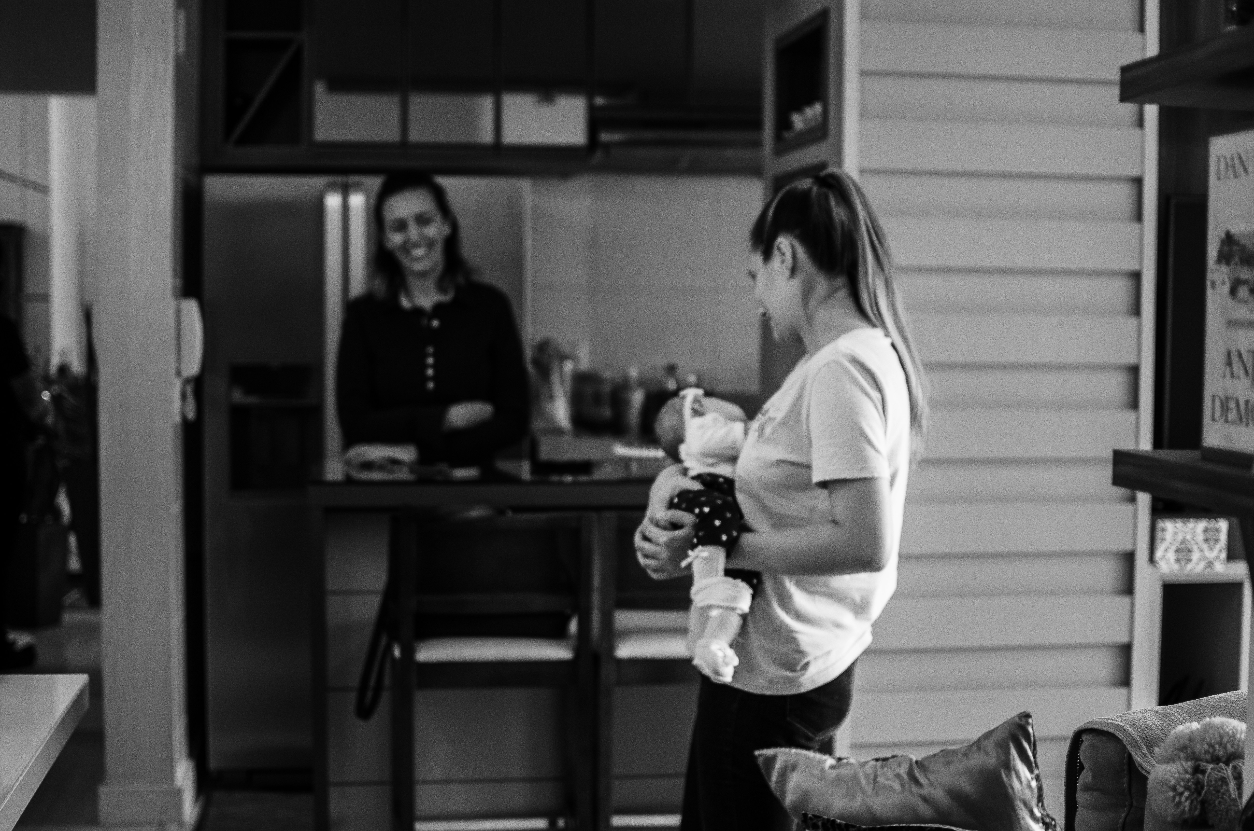 Foto en escala de grises de mujer con camisa de manga larga y pantalones sosteniendo una botella de vidrio