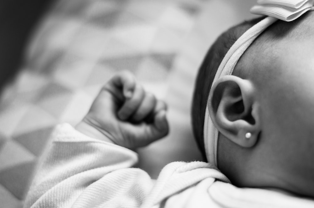 a close up of a baby laying on a bed