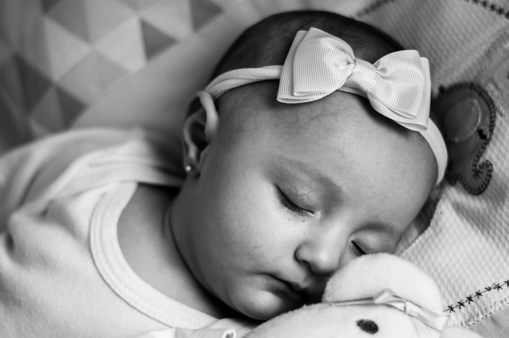 baby in white shirt lying on bed