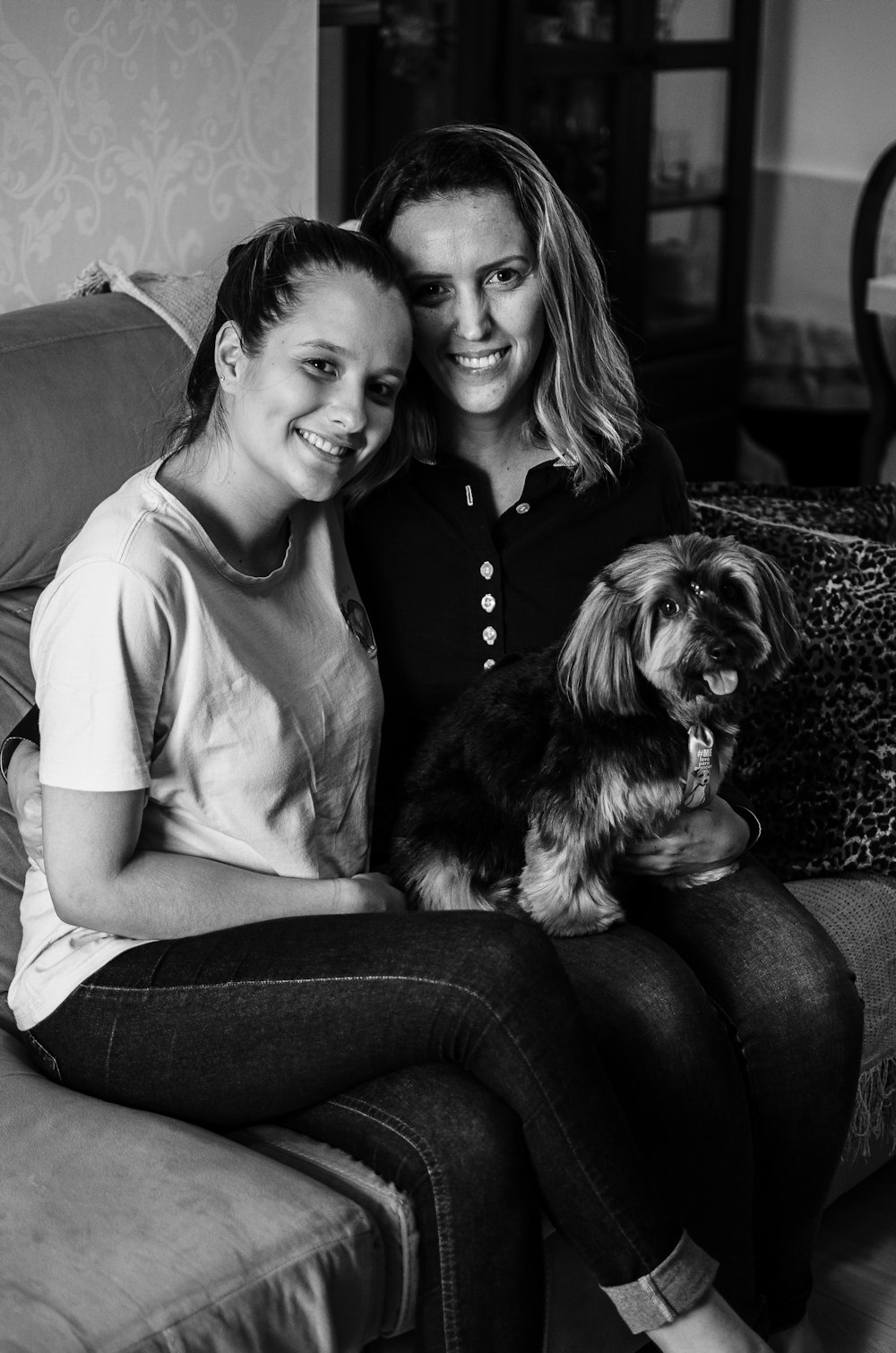 grayscale photo of woman and girl sitting on couch