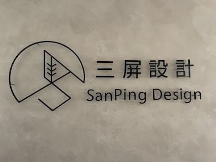 A minimalist logo with a circular geometric design and a stylized tree inside a partial circle. Accompanied by text in both Chinese characters and the English words 'SanPing Design' on a textured gray background.
