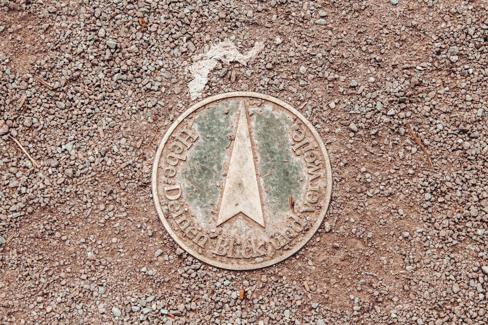 round silver coin on gray surface