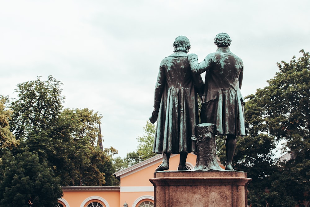 homem na estátua do casaco perto do edifício marrom