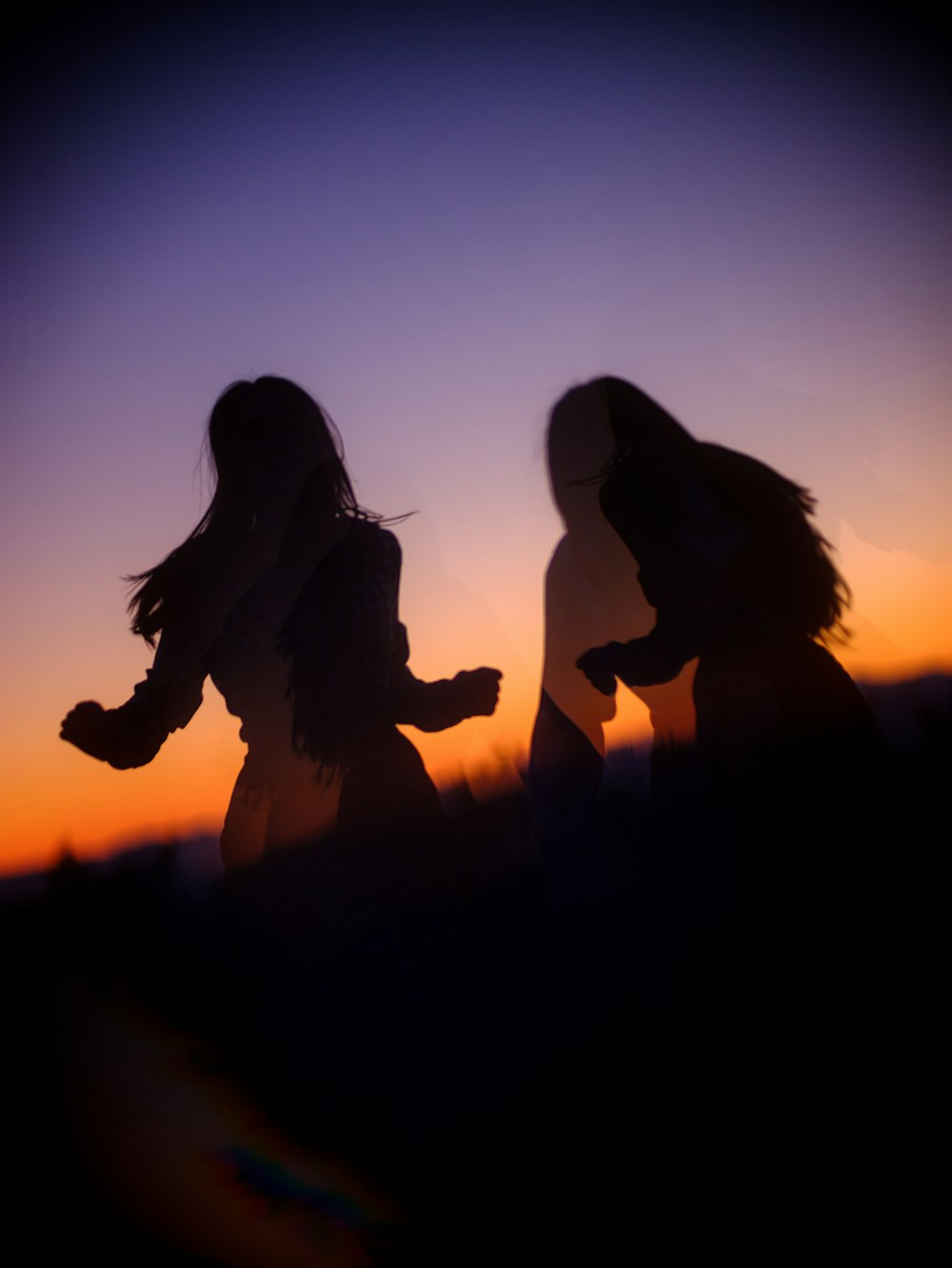 silhouette of 2 women kissing during sunset