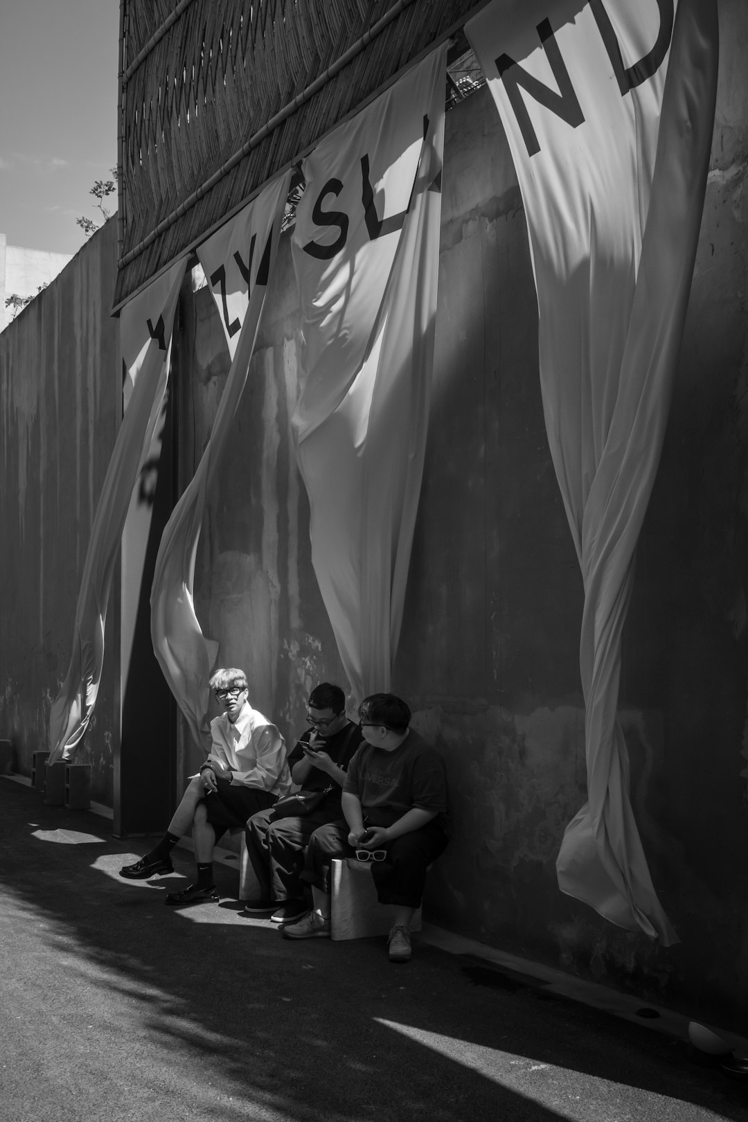 grayscale photo of people sitting on bench