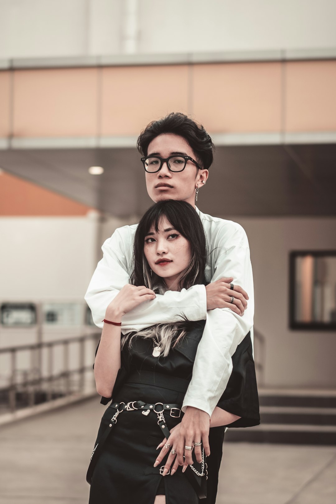 man in white dress shirt hugging woman in black dress