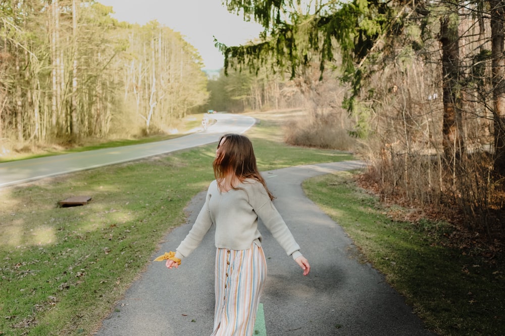 woman in beige long sleeve shirt and red white and black plaid skirt walking on gray