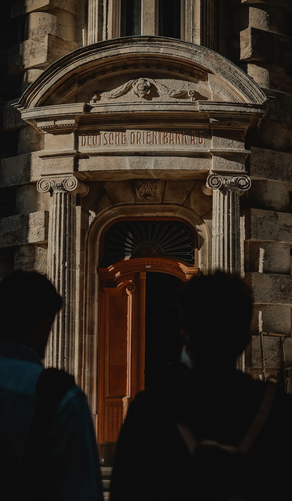 people standing in front of brown wooden door