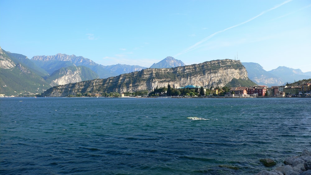 body of water near mountain during daytime