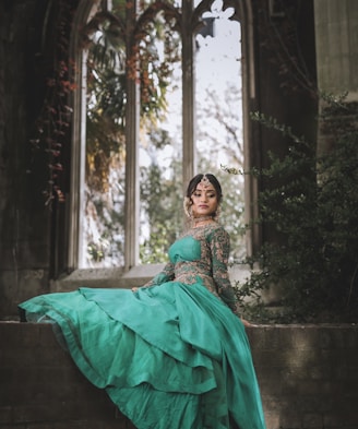 woman in green dress sitting on concrete bench