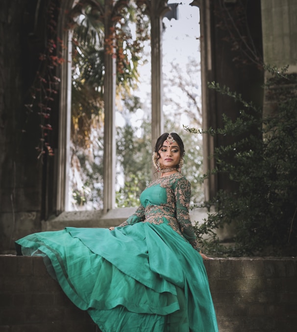 woman in green dress sitting on concrete bench