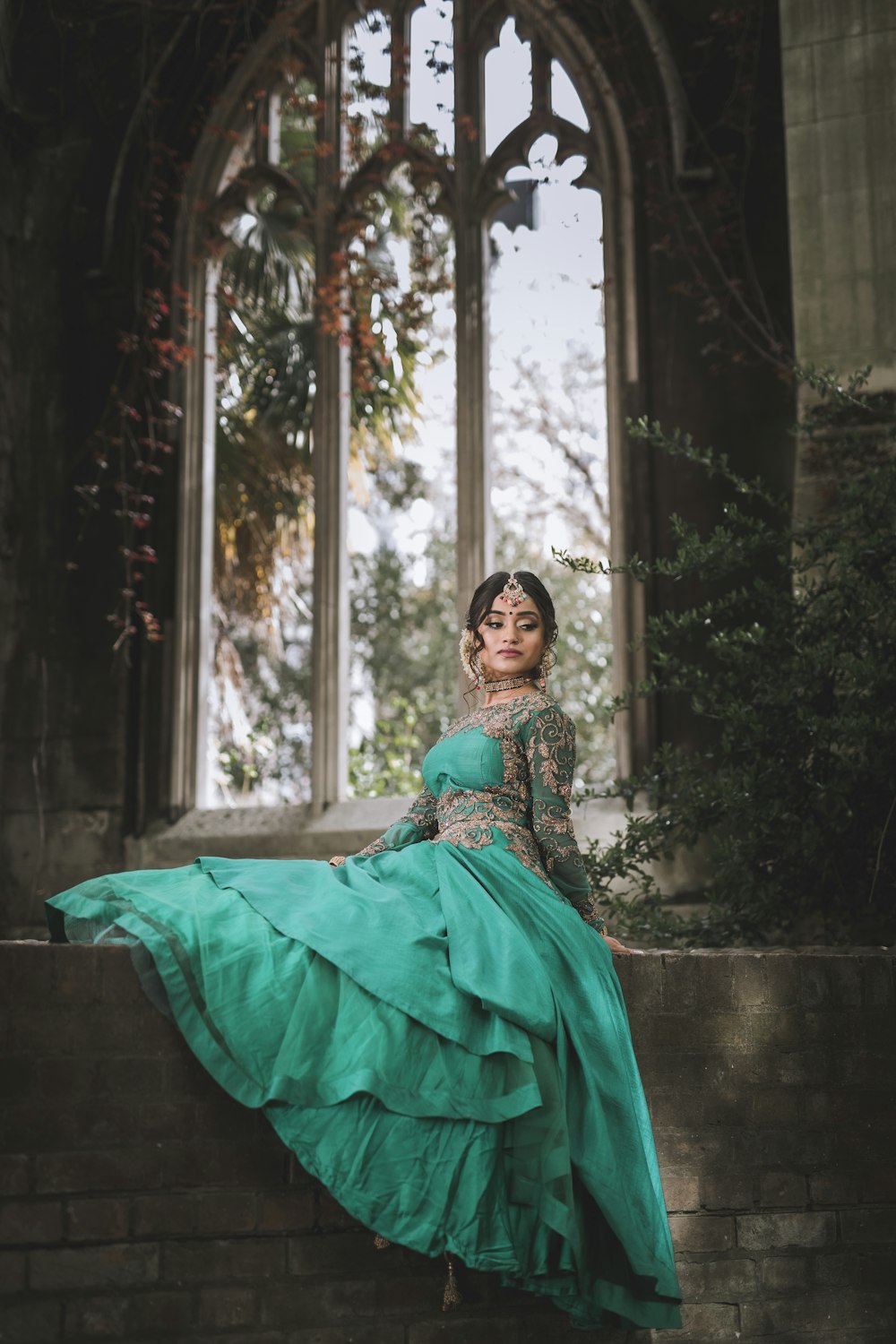 woman in green dress sitting on concrete bench