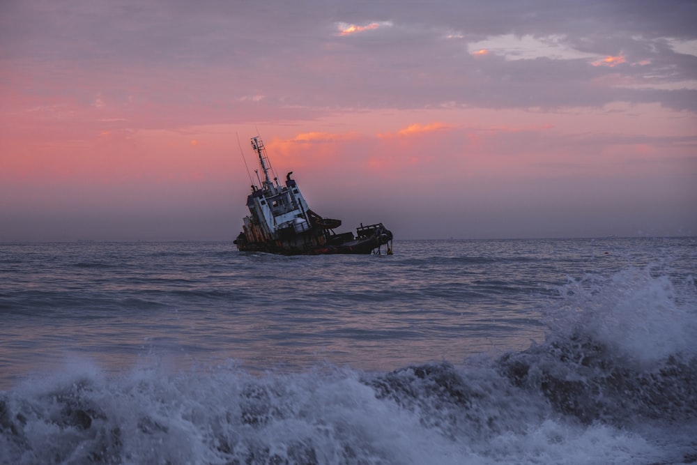 white and black boat on sea during sunset