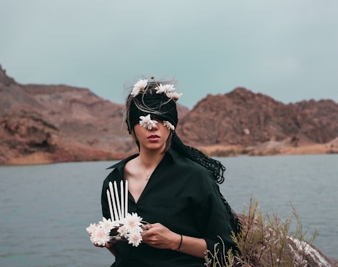 woman in black long sleeve shirt holding white flower