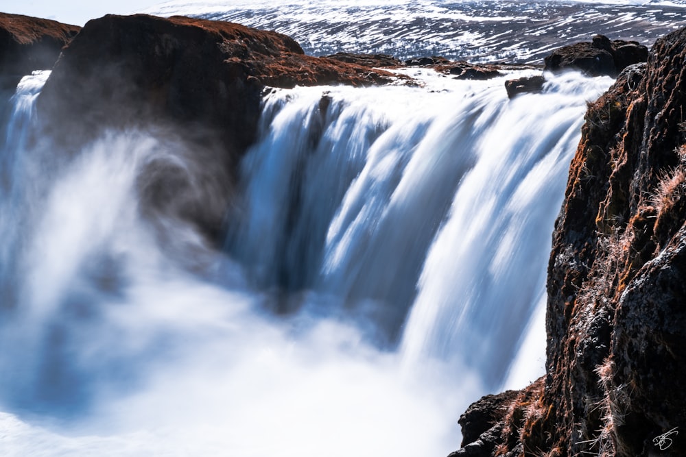 water falls on brown rocky mountain