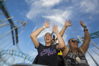 A joyful family riding a colorful roller coaster together, smiling and holding hands.