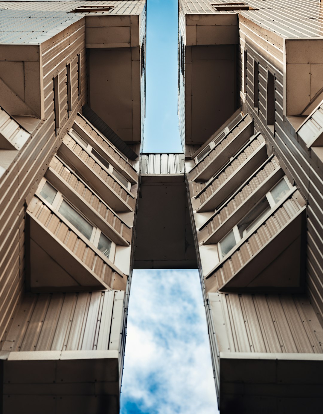 low angle photography of brown concrete building under blue sky during daytime