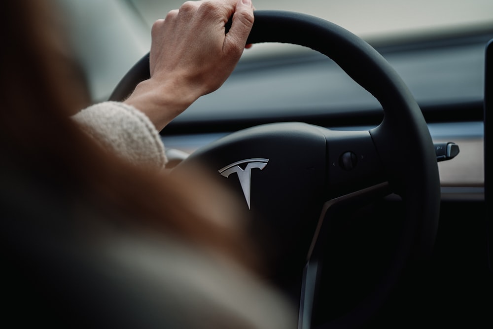 person holding black and gray car steering wheel