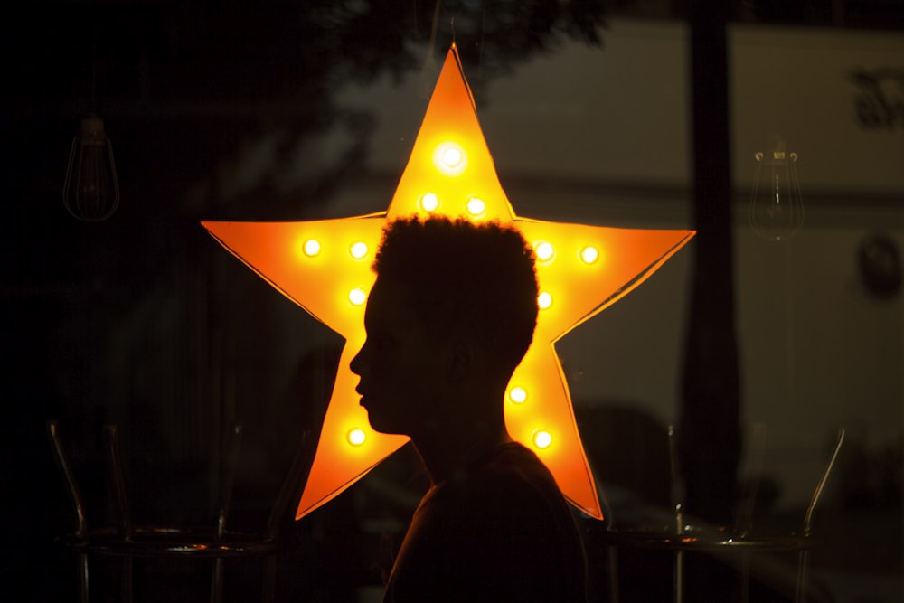 person in black jacket with orange umbrella during night time