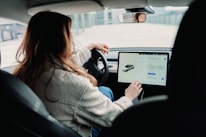 Close-up of a driver happily checking sedan features on a tablet.