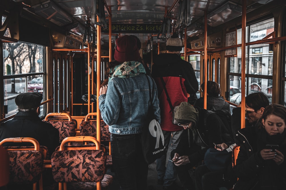 man in blue denim jacket standing beside woman in red jacket