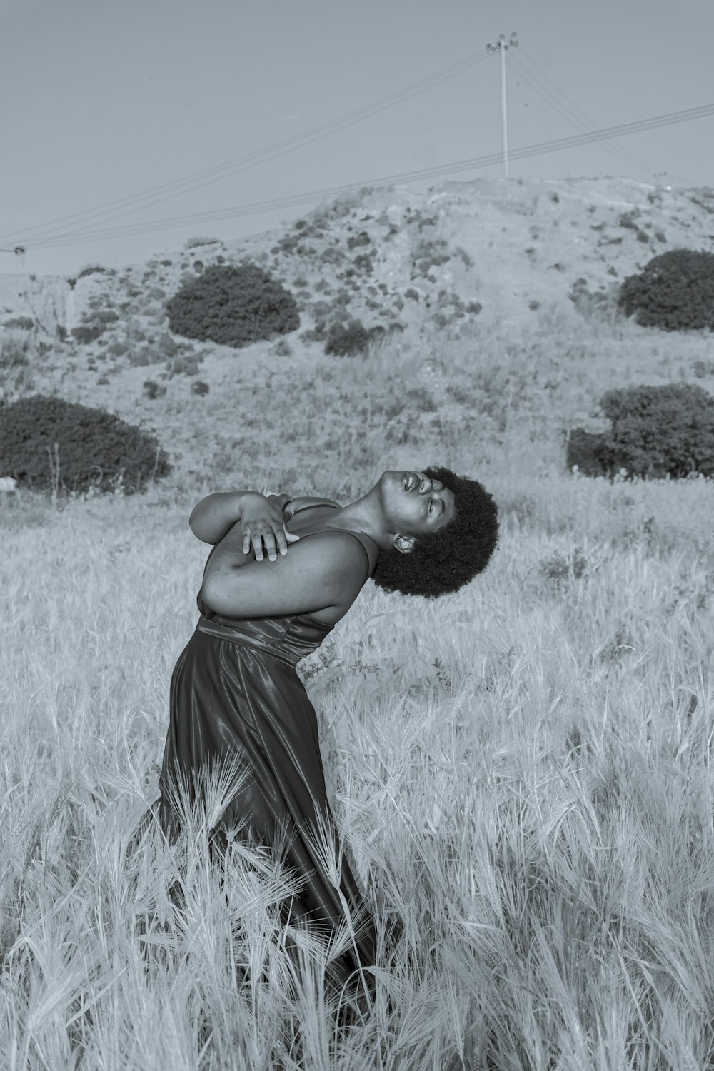 woman in black spaghetti strap dress standing on grass field