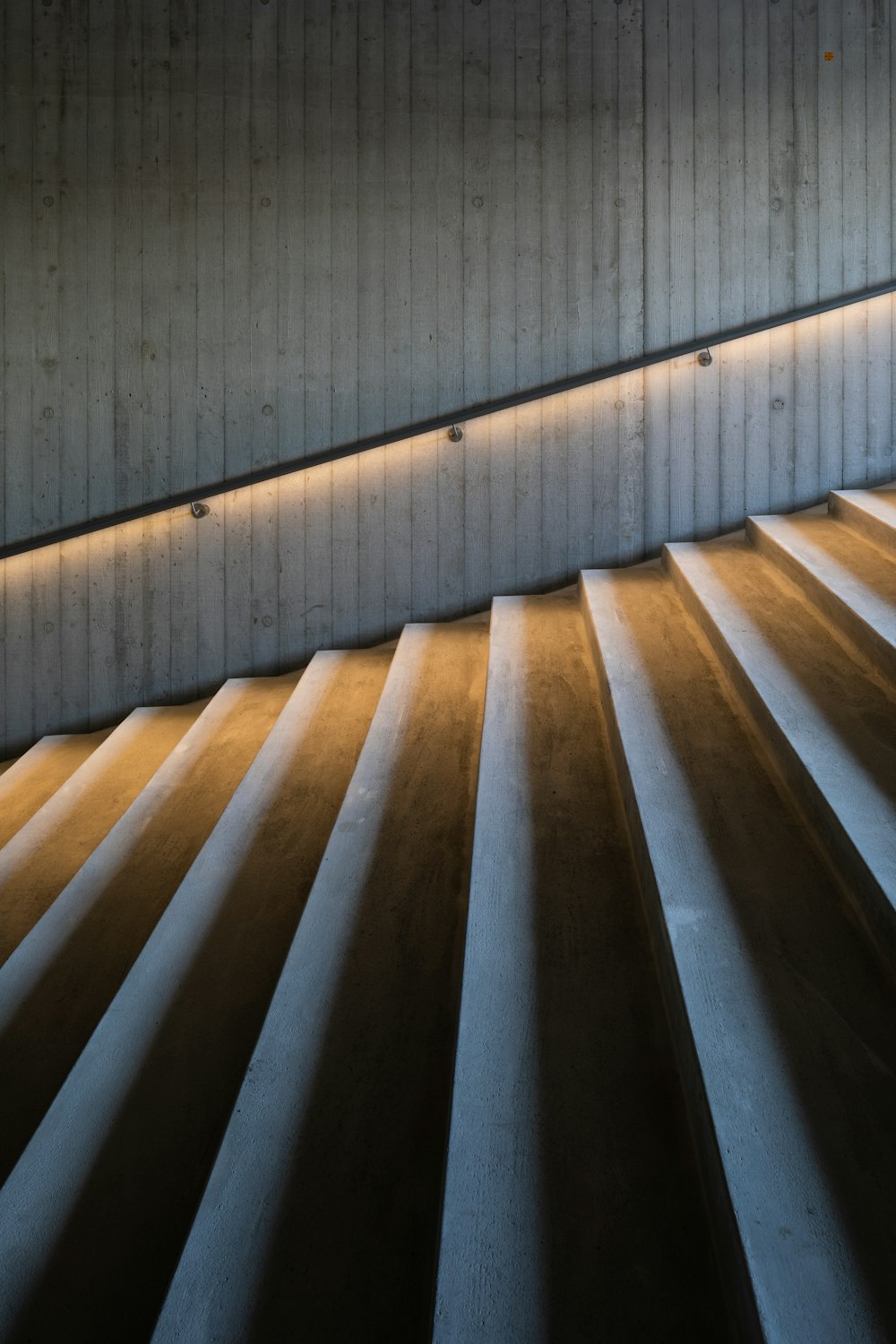 Escalera de madera marrón con barandillas de acero inoxidable