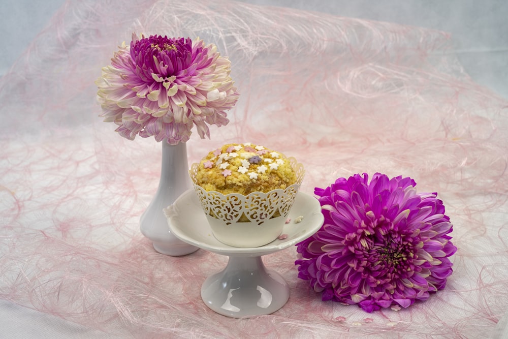 Flores rosadas y amarillas en jarrón de cerámica blanca