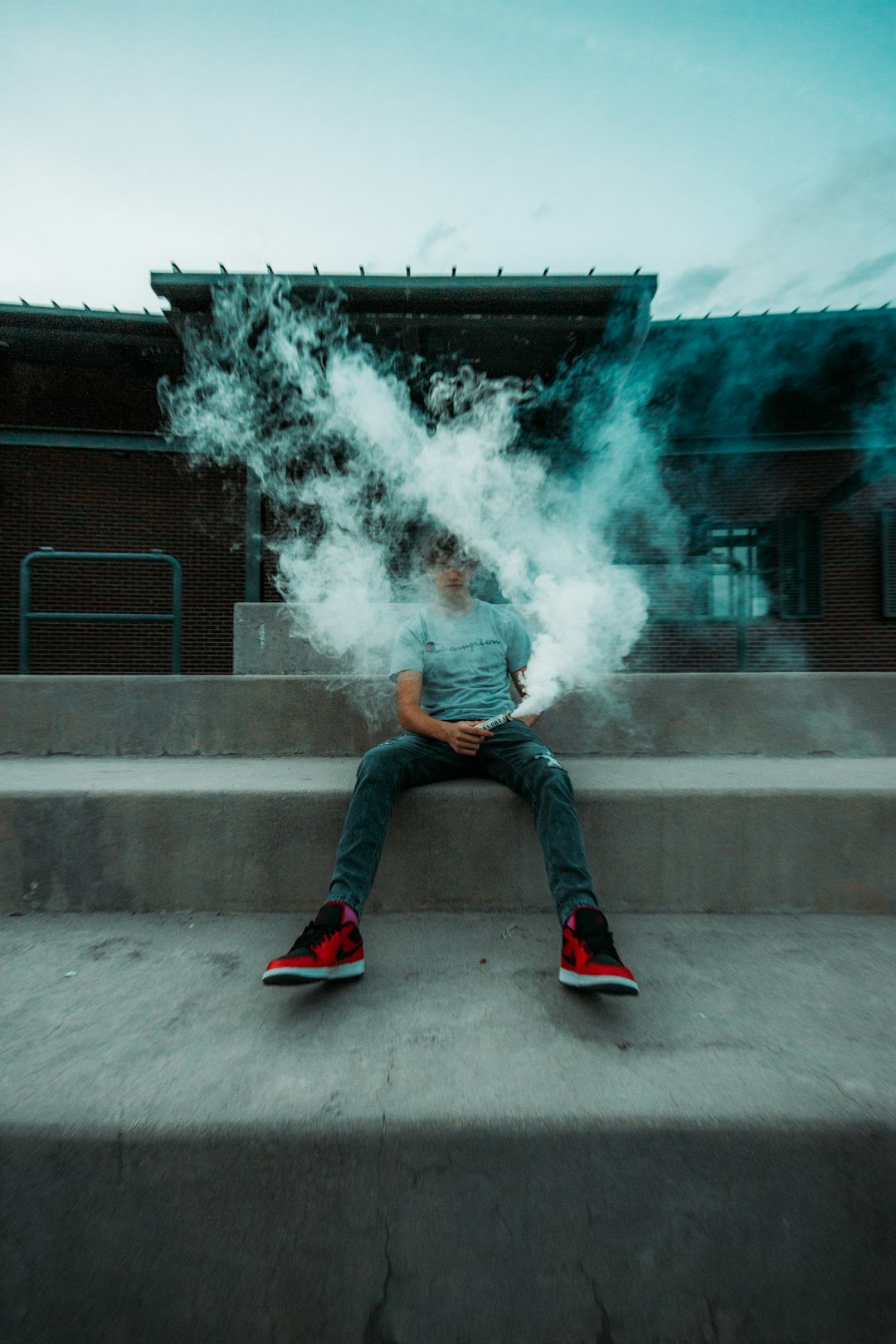 woman in blue denim jeans and red sneakers sitting on concrete stairs