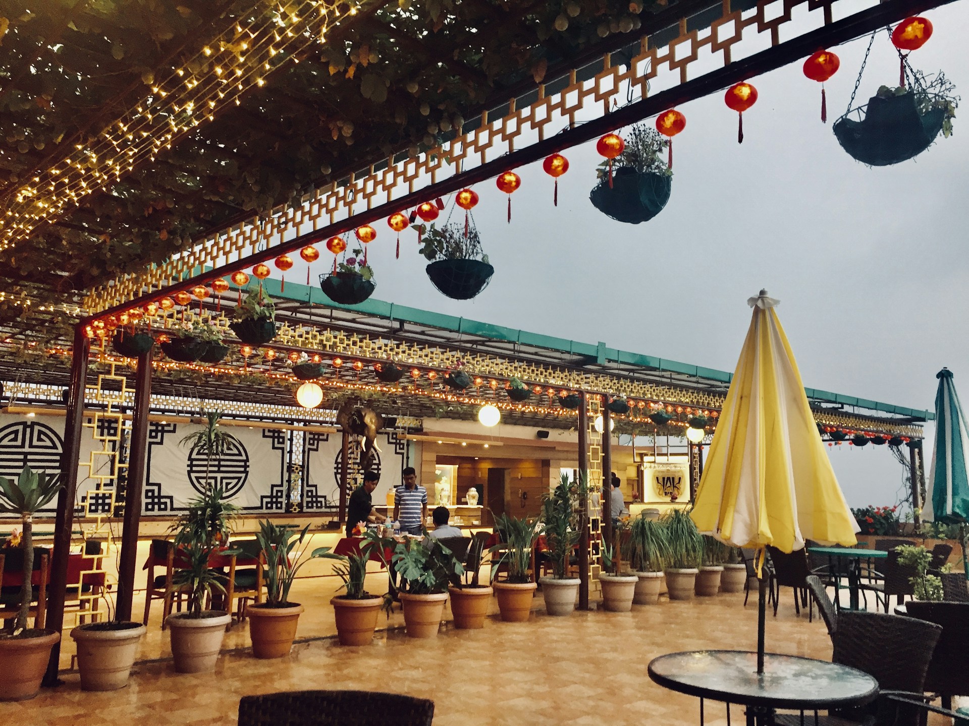 A serene outdoor dining area with lanterns and bamboo decor.
