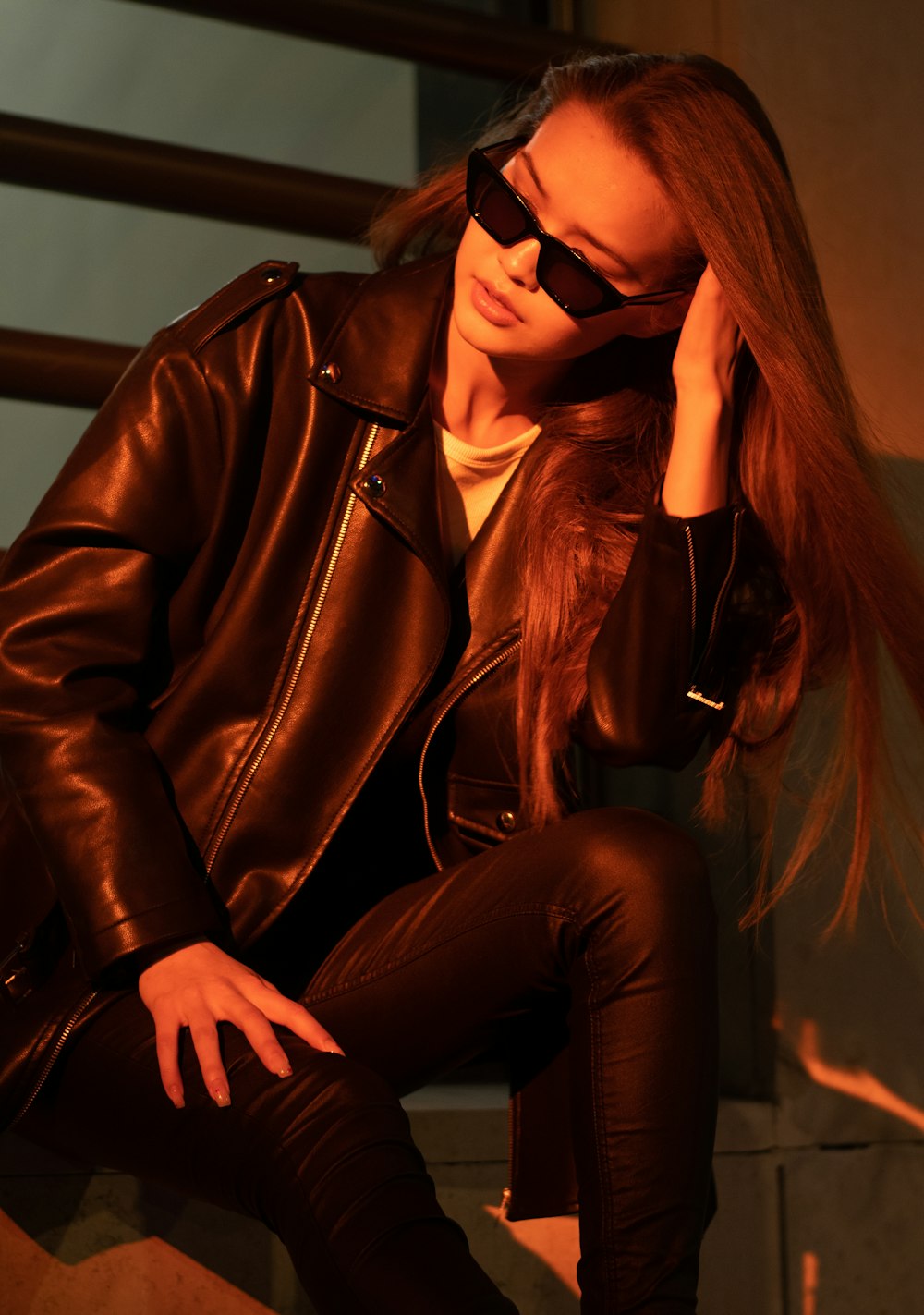 woman in brown leather jacket and black pants wearing black sunglasses