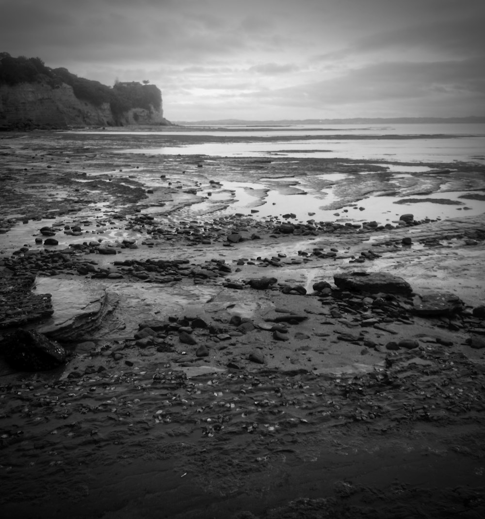 grayscale photo of sea waves crashing on rocks