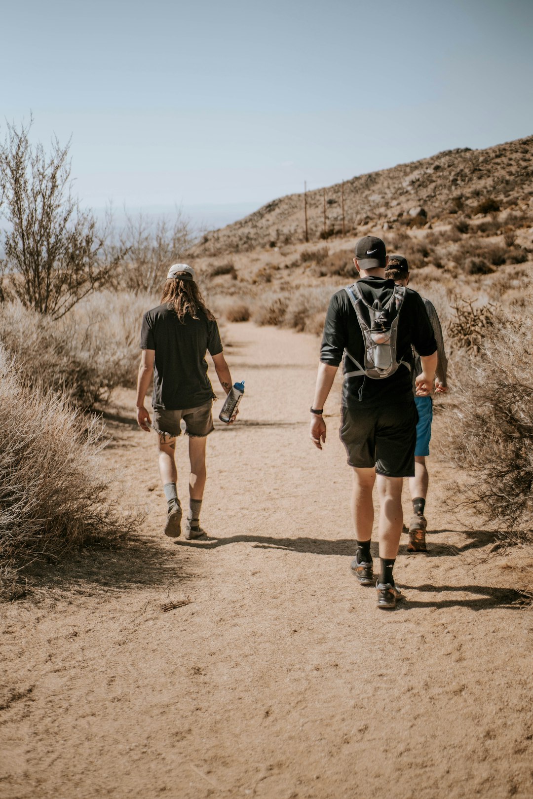 man and woman walking on brown dirt road during daytime