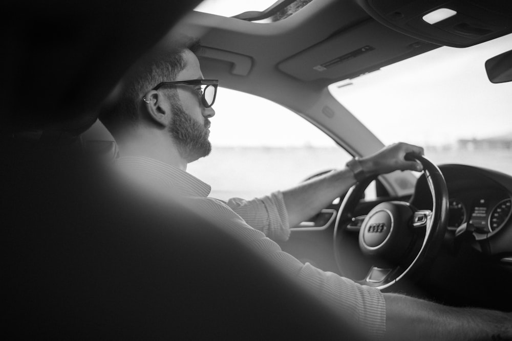 man in black shirt driving car during daytime