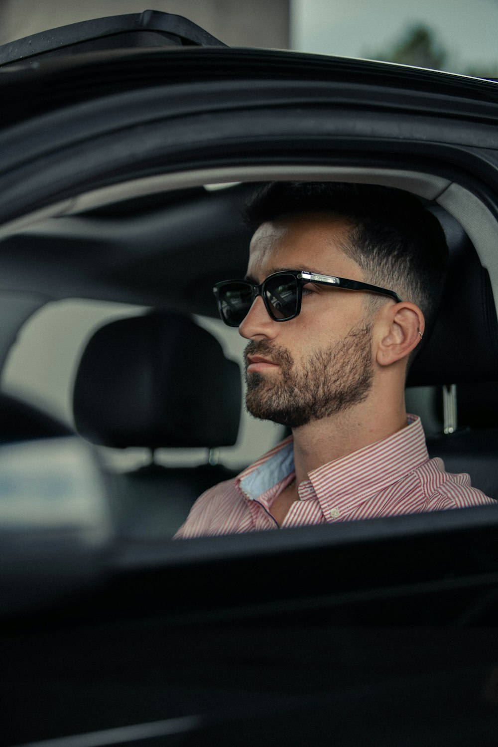 man in red and white striped dress shirt wearing black sunglasses