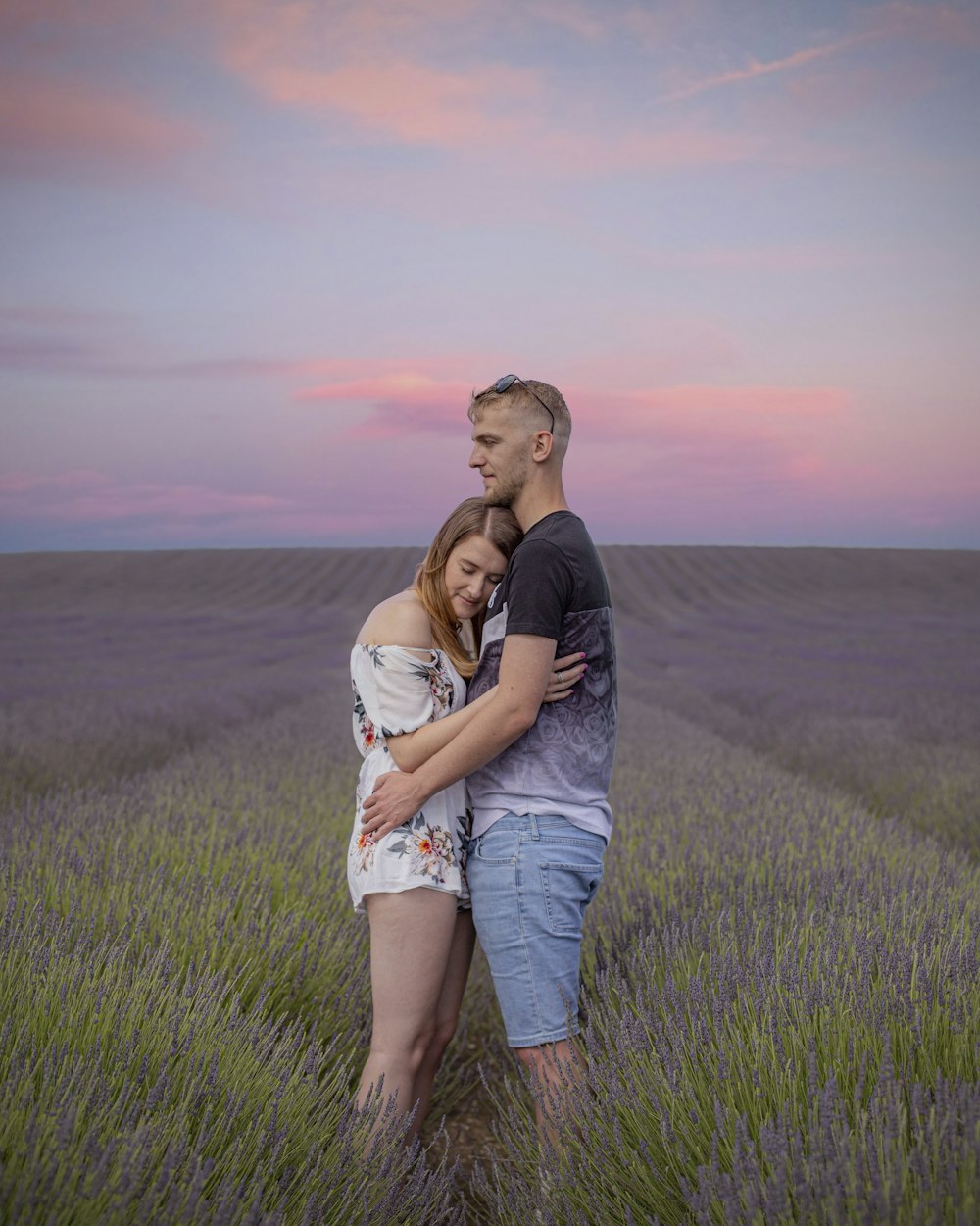homem e mulher que beijam no campo de grama verde durante o dia