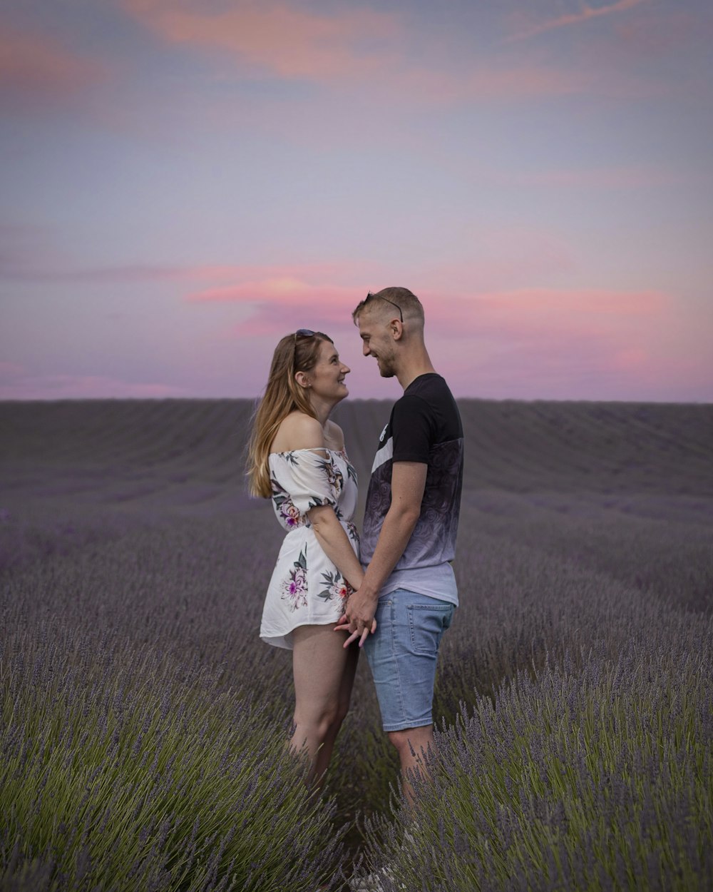 a man and a woman standing in a lavender field