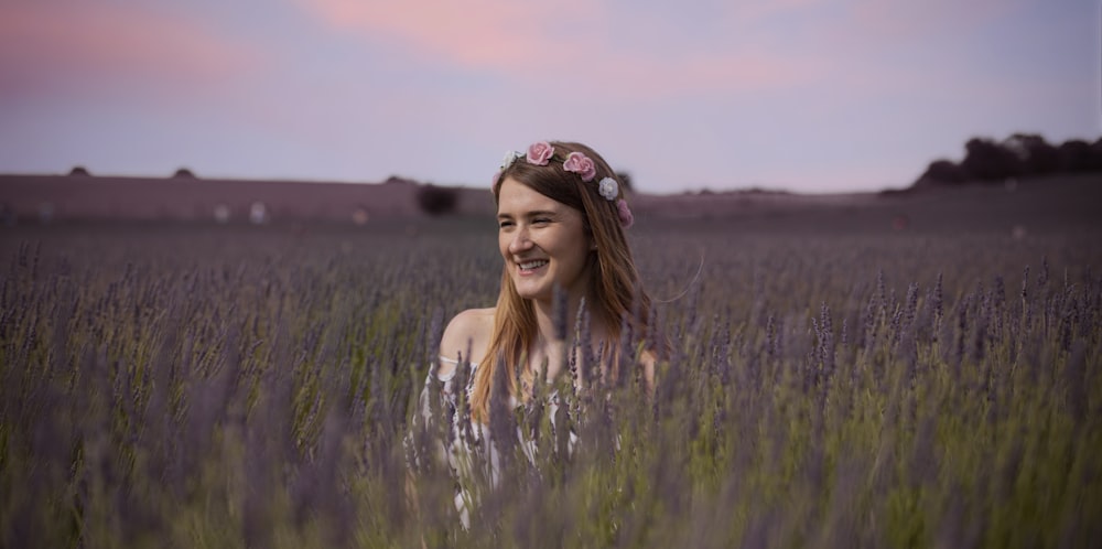 woman in white tank top standing on green grass field during daytime