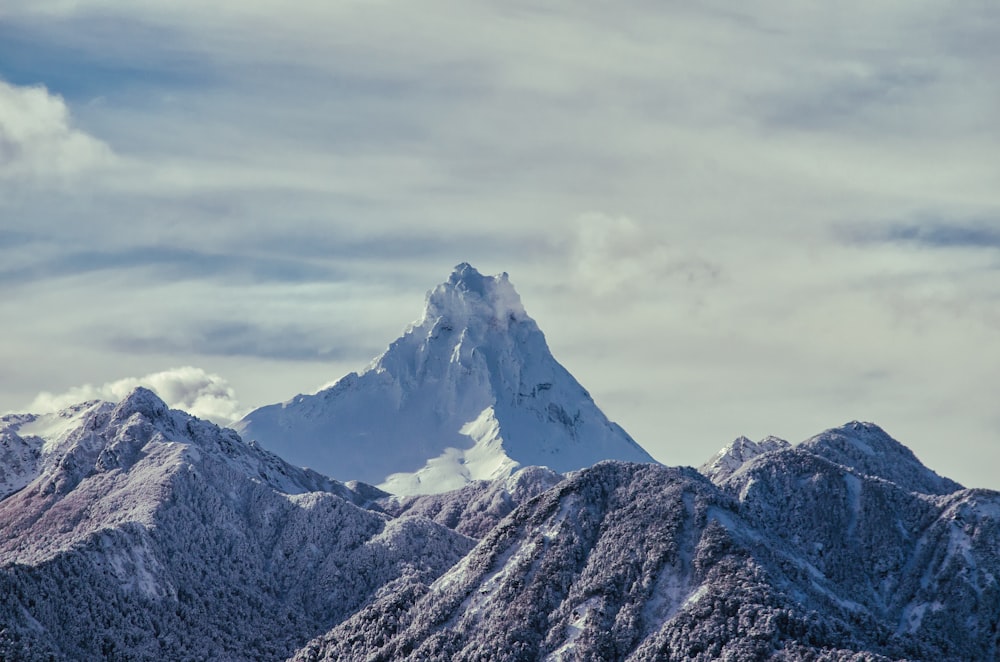 montagna innevata sotto il cielo nuvoloso durante il giorno