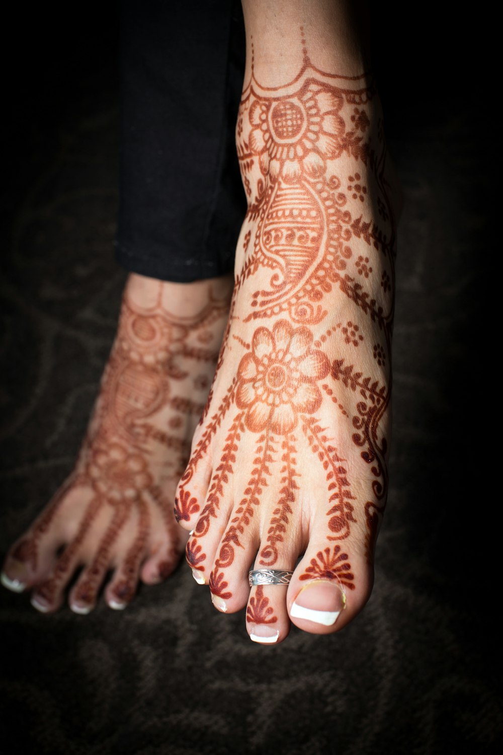 Persona con tatuaje floral rojo y blanco en la mano izquierda