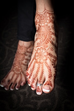 person with red and white floral tattoo on left hand