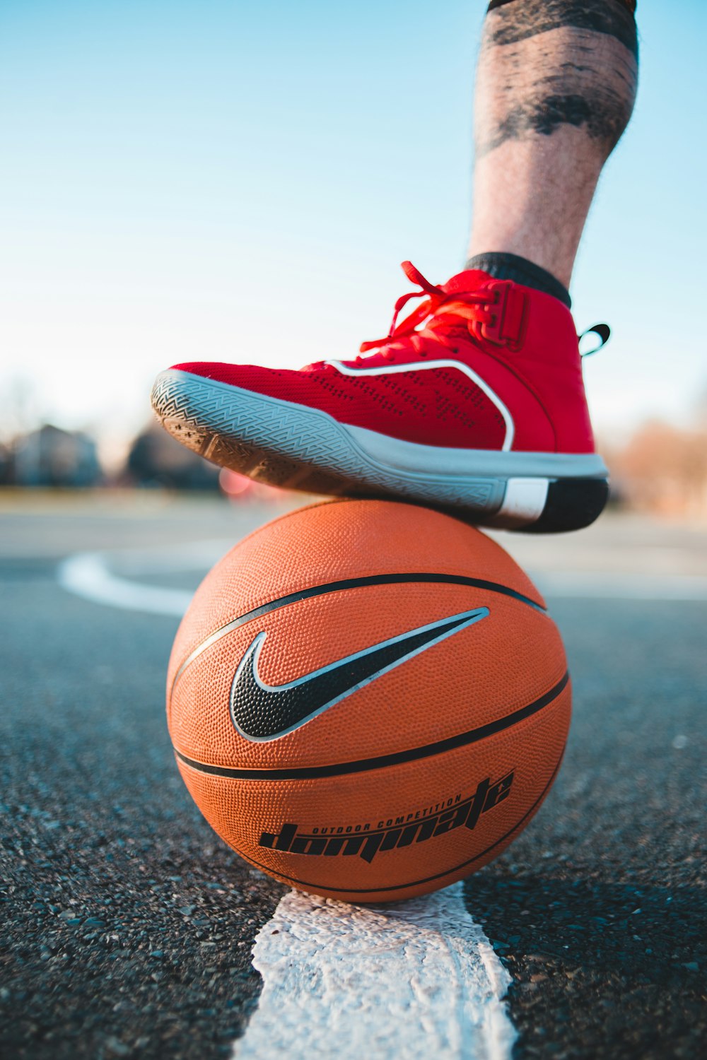 person in red nike basketball shoes and black and white nike basketball shoes