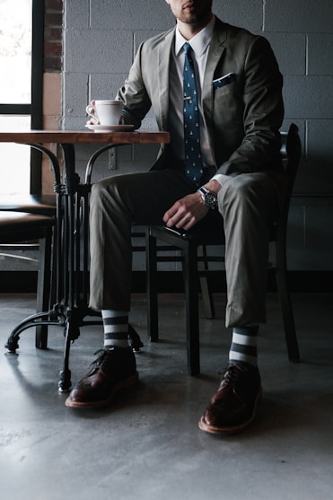 man in black suit sitting on chair