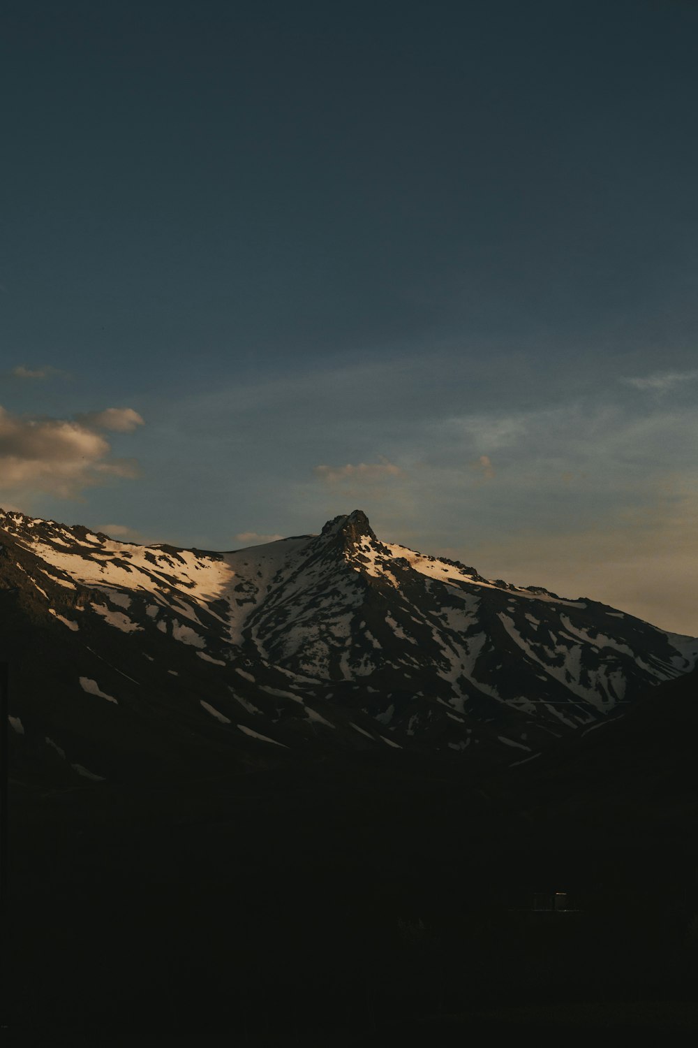 montagne noire et blanche sous ciel bleu