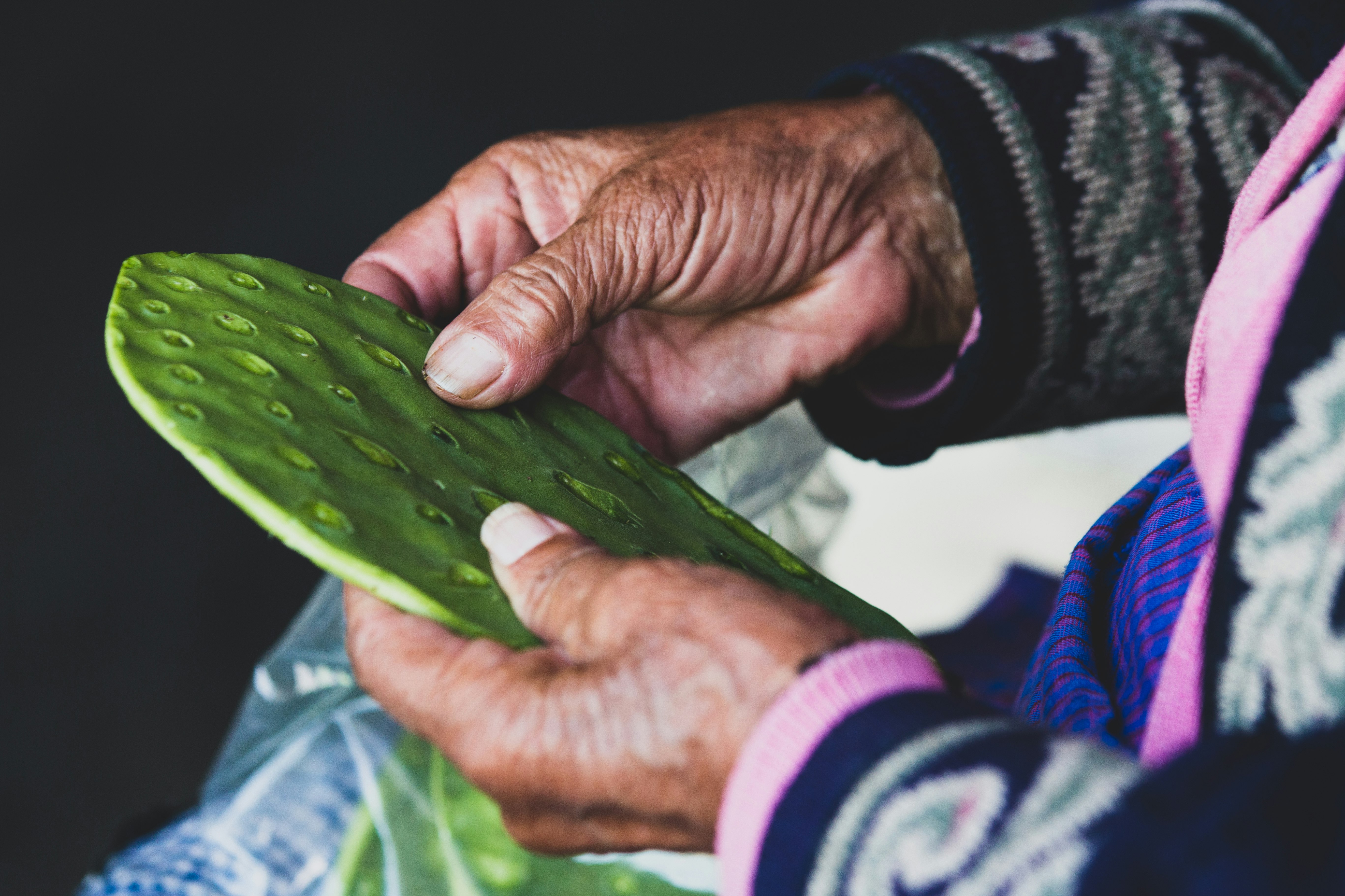 A woman picks out the spines from nopales.