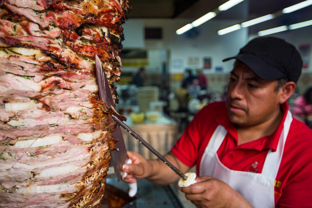 man in red and white polo shirt holding stainless steel fork