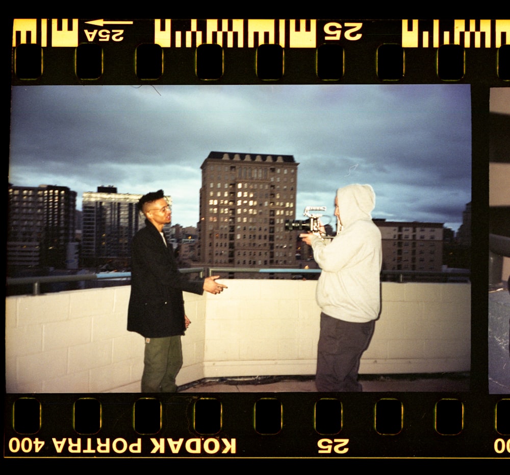 man and woman standing on top of building during night time