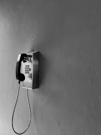 A stark two-tone image of a prison phone receiver framed by monospaced typewriter text resembling a classified dossier.